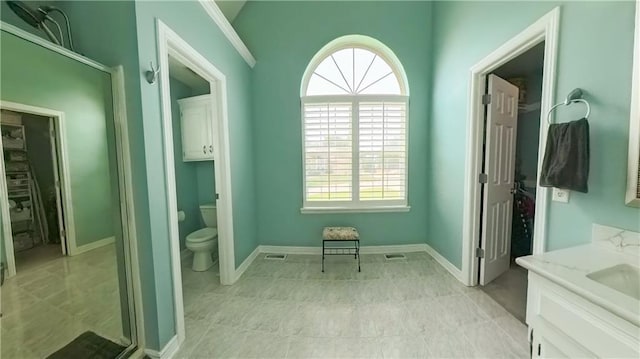 bathroom with vanity, toilet, and baseboards