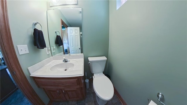 bathroom featuring vanity, toilet, and baseboards