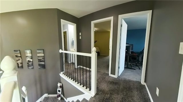 hall featuring carpet, an upstairs landing, and baseboards