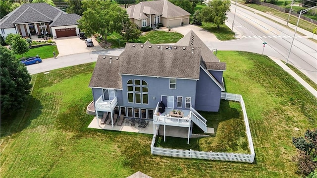 back of property featuring a garage, a patio area, a shingled roof, and stucco siding