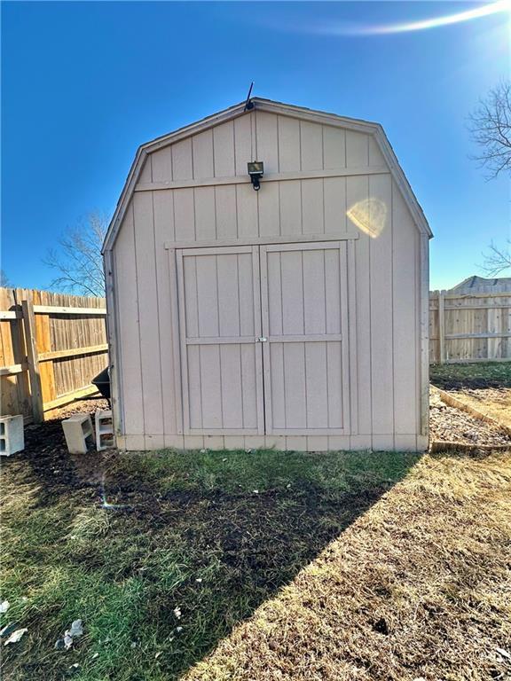 view of shed featuring fence