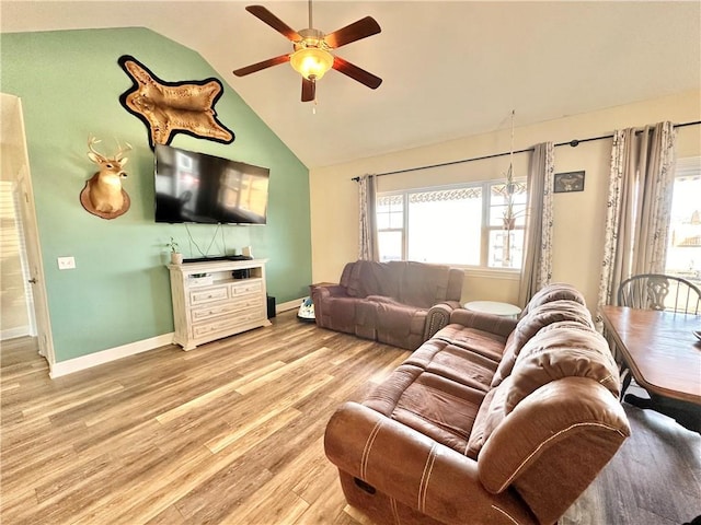 living room with a ceiling fan, light wood-type flooring, lofted ceiling, and baseboards