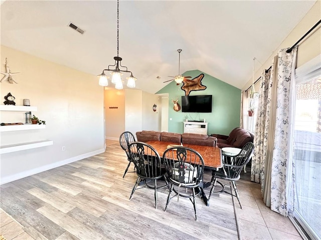 dining area with light wood-style flooring, a ceiling fan, visible vents, vaulted ceiling, and baseboards