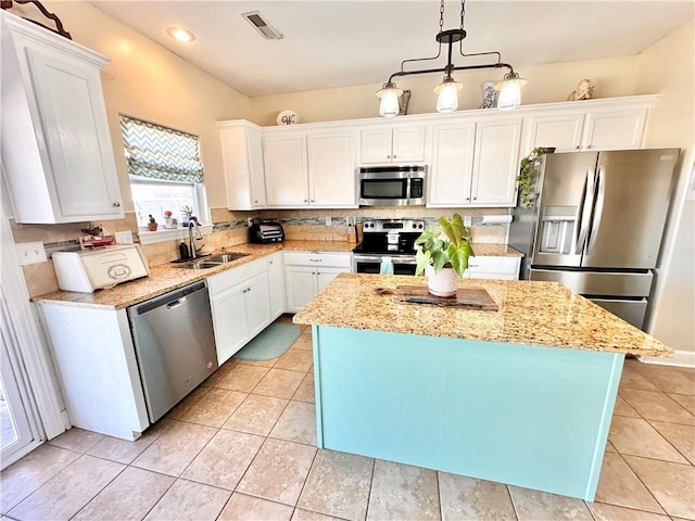 kitchen featuring appliances with stainless steel finishes, a sink, and white cabinetry