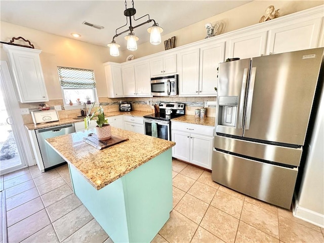 kitchen featuring light tile patterned floors, appliances with stainless steel finishes, white cabinets, and tasteful backsplash