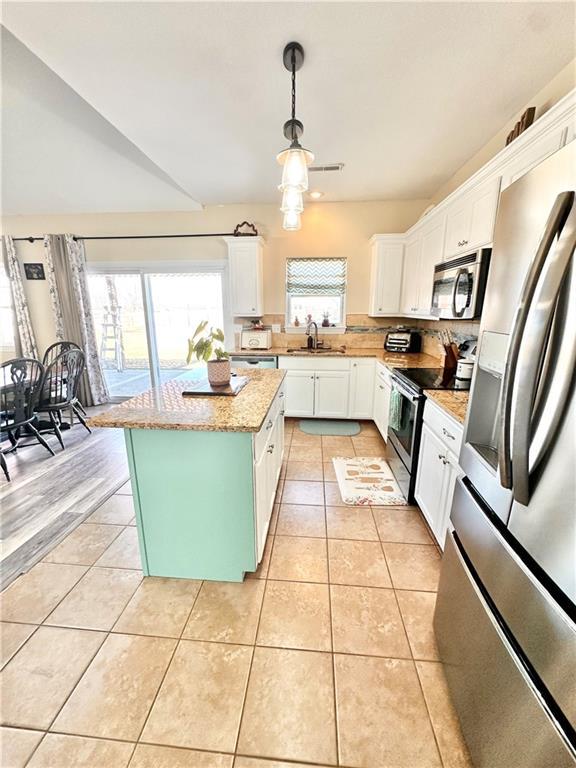 kitchen featuring white cabinetry, stainless steel appliances, a sink, and light tile patterned flooring