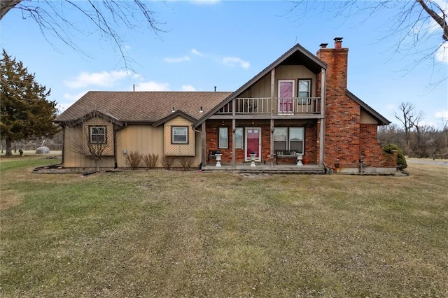 back of house featuring a yard, a chimney, and a balcony