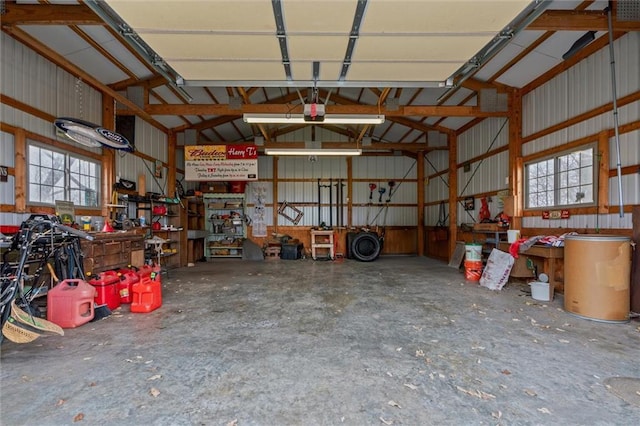 garage featuring a workshop area, metal wall, and a garage door opener