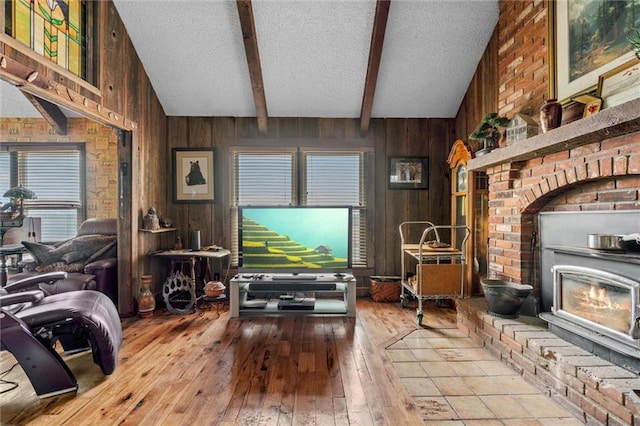 living room featuring vaulted ceiling with beams, hardwood / wood-style flooring, wooden walls, and a textured ceiling