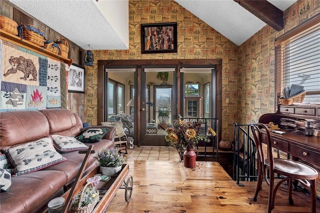 living room with lofted ceiling with beams, a textured ceiling, and a healthy amount of sunlight