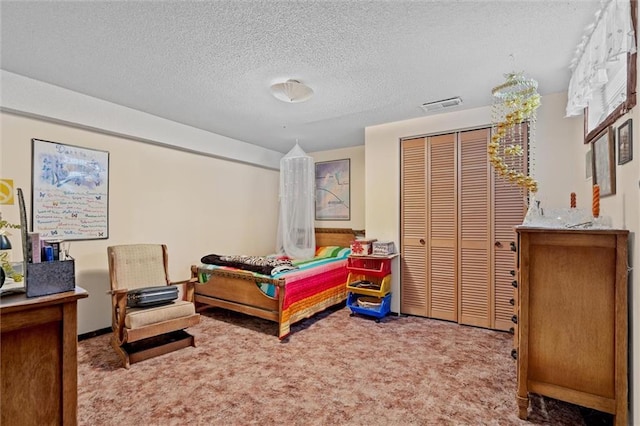 carpeted bedroom with a textured ceiling, visible vents, and a closet