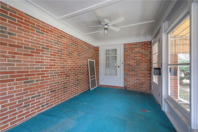 unfurnished sunroom featuring a ceiling fan