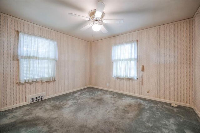 carpeted spare room with visible vents, ceiling fan, baseboards, and wallpapered walls