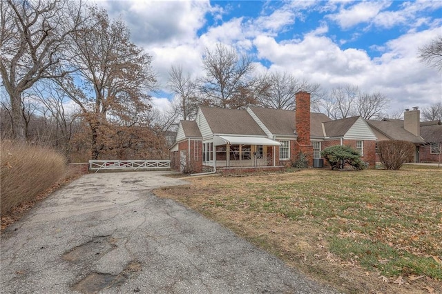 8715 High Dr, Leawood, KS 66206 - view of front of property with asphalt driveway, brick siding, covered porch, and a gate