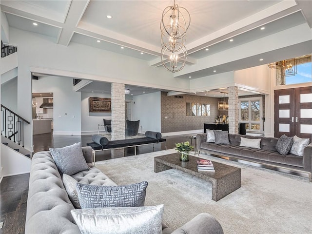 living room featuring stairway, ornate columns, a chandelier, beam ceiling, and recessed lighting