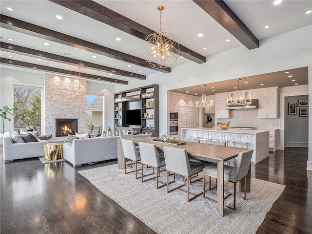 dining space featuring a chandelier, recessed lighting, a large fireplace, and dark wood-style floors