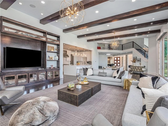 living area with beam ceiling, recessed lighting, wood finished floors, a chandelier, and stairs