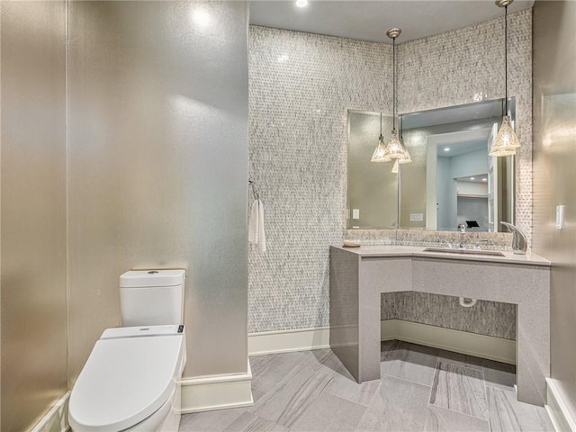 bathroom featuring baseboards, vanity, and toilet