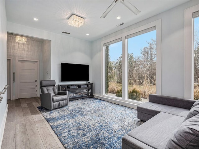 living room featuring a wealth of natural light, wood-type flooring, and visible vents