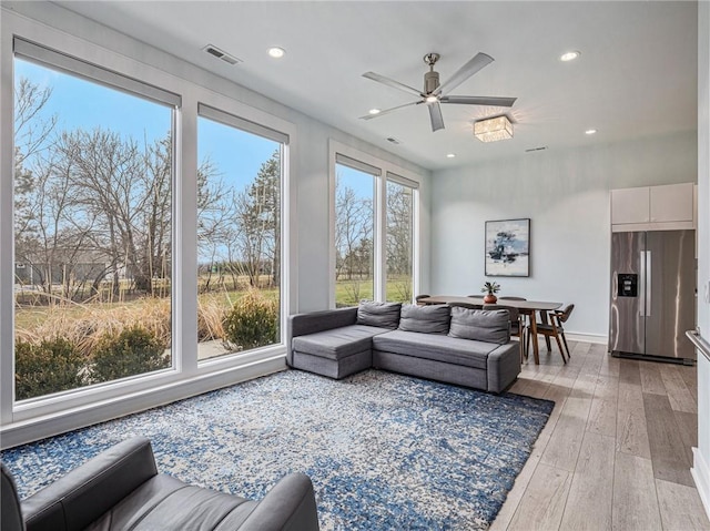 living area with light wood-type flooring, ceiling fan, visible vents, and recessed lighting