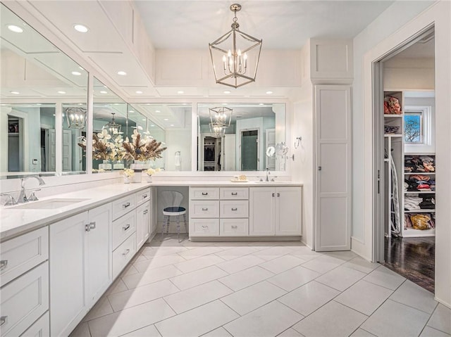 full bath with tile patterned flooring, a walk in closet, vanity, a chandelier, and recessed lighting