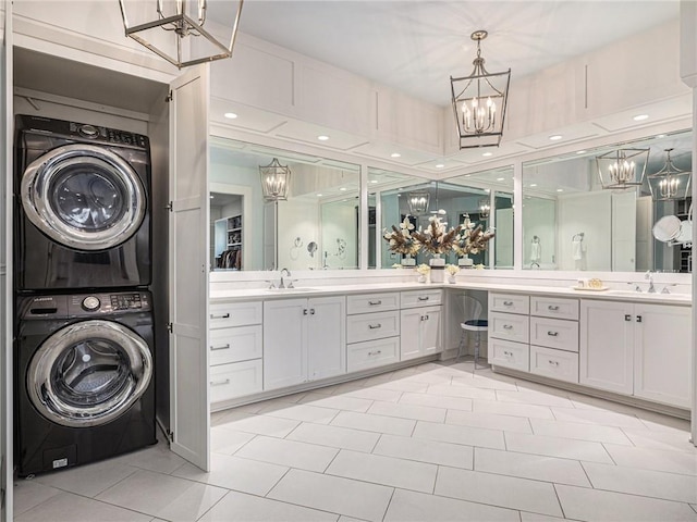 full bathroom featuring stacked washer and dryer, tile patterned flooring, vanity, and a notable chandelier