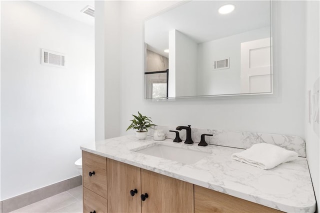 bathroom featuring tile patterned flooring, visible vents, vanity, and toilet