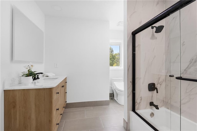 bathroom with baseboards, bath / shower combo with glass door, toilet, tile patterned floors, and vanity