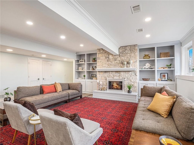 living area with a fireplace, recessed lighting, visible vents, ornamental molding, and wood finished floors