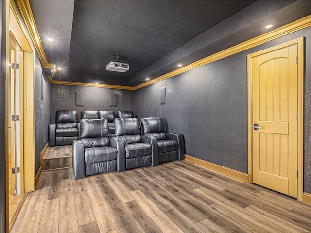 cinema featuring baseboards, wood finished floors, and crown molding