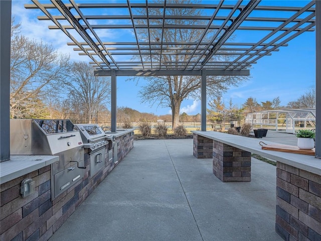 view of patio with a pergola, exterior kitchen, and area for grilling