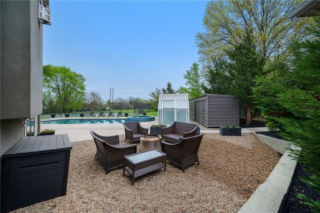 view of patio featuring a greenhouse, a pool with connected hot tub, an outdoor structure, and fence