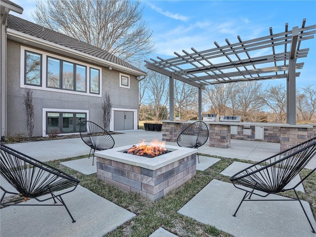 view of patio featuring a fire pit, an outdoor kitchen, and a pergola