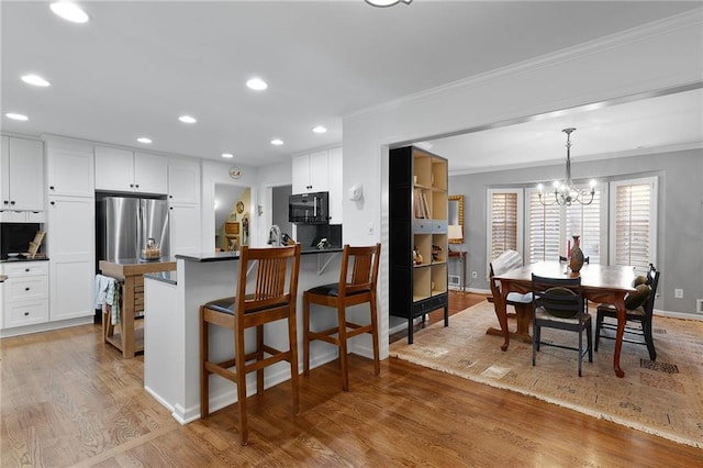 dining room with crown molding, recessed lighting, wood finished floors, and baseboards