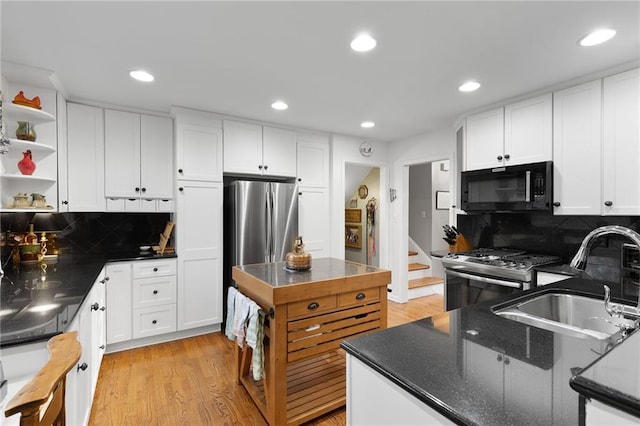 kitchen with open shelves, a sink, stainless steel appliances, white cabinets, and light wood-type flooring