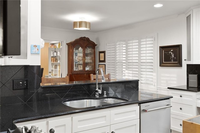 kitchen with tasteful backsplash, dishwasher, ornamental molding, white cabinets, and a sink