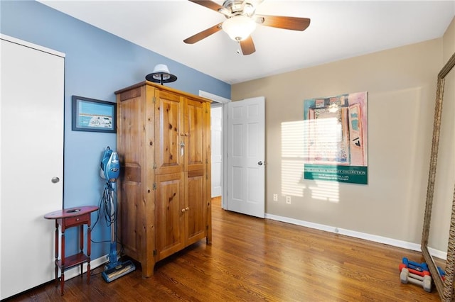 bedroom featuring ceiling fan, baseboards, and wood finished floors