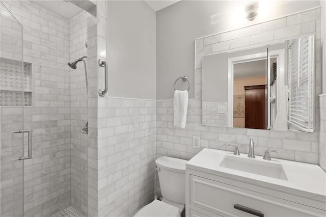 full bath featuring tile walls, a shower stall, toilet, and vanity