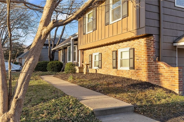 view of side of home with brick siding and board and batten siding