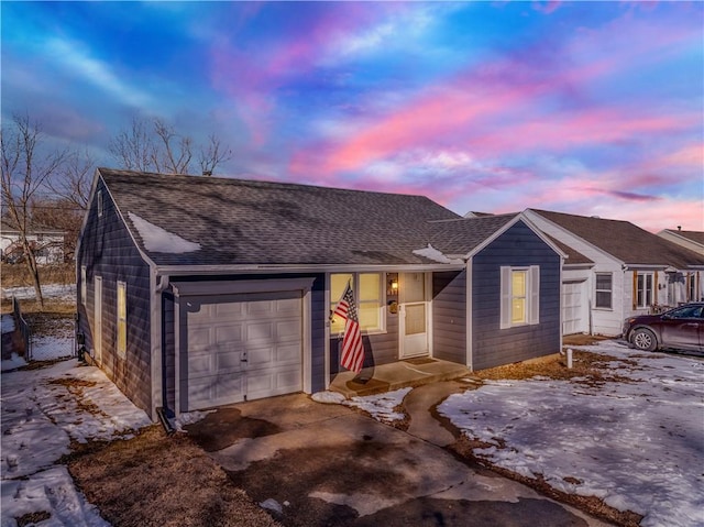 single story home with a garage, concrete driveway, and roof with shingles