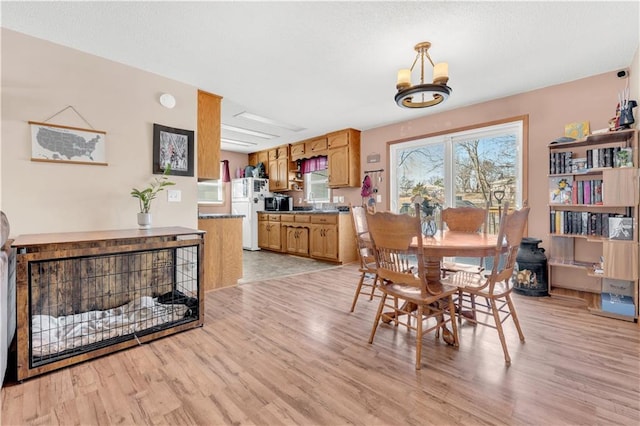 dining room featuring light wood-style flooring and a notable chandelier