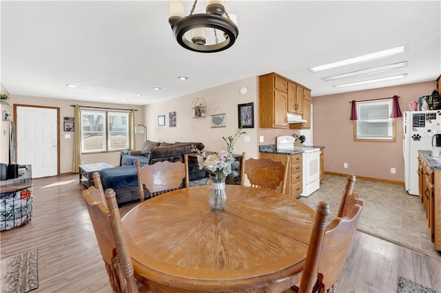 dining area with light wood finished floors and baseboards