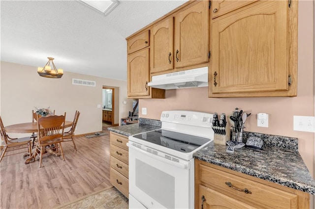 kitchen featuring white electric stove, visible vents, light brown cabinetry, light wood-type flooring, and under cabinet range hood