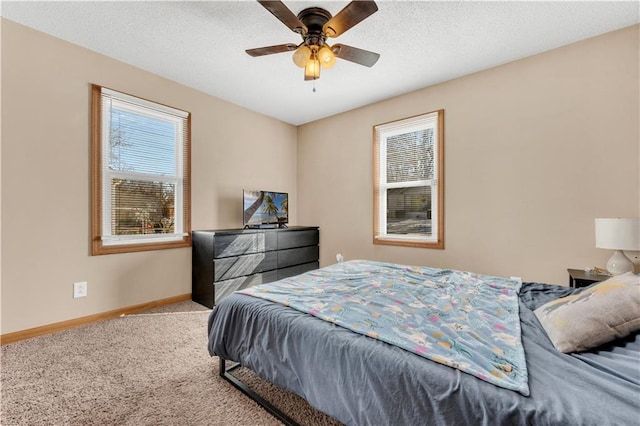 bedroom with carpet, multiple windows, a textured ceiling, and baseboards