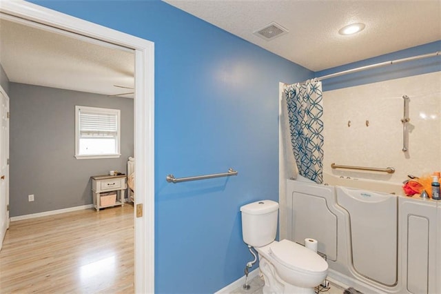 5990 Z Hwy, Edgerton, MO 64444 - full bath with a textured ceiling, wood finished floors, shower / bath combination with curtain, toilet, and baseboards