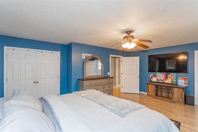 5990 Z Hwy, Edgerton, MO 64444 - bedroom featuring a textured ceiling, light wood-type flooring, a closet, a ceiling fan, and baseboards