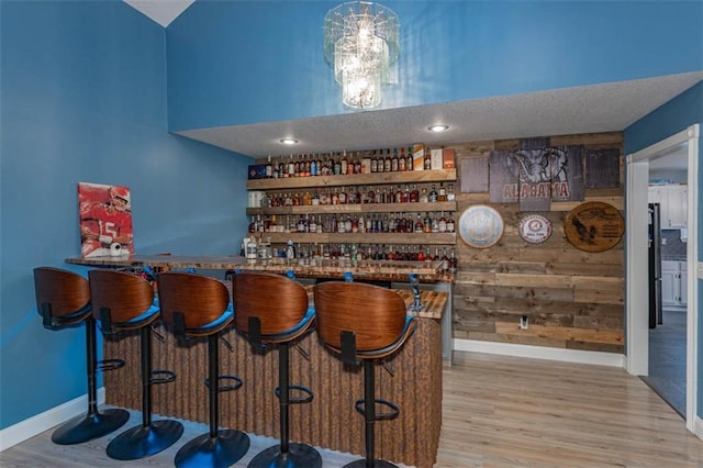 5990 Z Hwy, Edgerton, MO 64444 - indoor dry bar featuring baseboards, wood finished floors, wood walls, and freestanding refrigerator