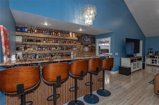 5990 Z Hwy, Edgerton, MO 64444 - indoor bar with wood finished floors, high vaulted ceiling, and a chandelier
