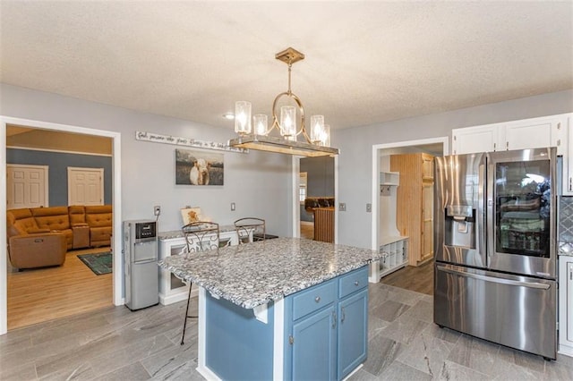 5990 Z Hwy, Edgerton, MO 64444 - kitchen featuring stainless steel fridge with ice dispenser, blue cabinetry, a chandelier, white cabinets, and a textured ceiling