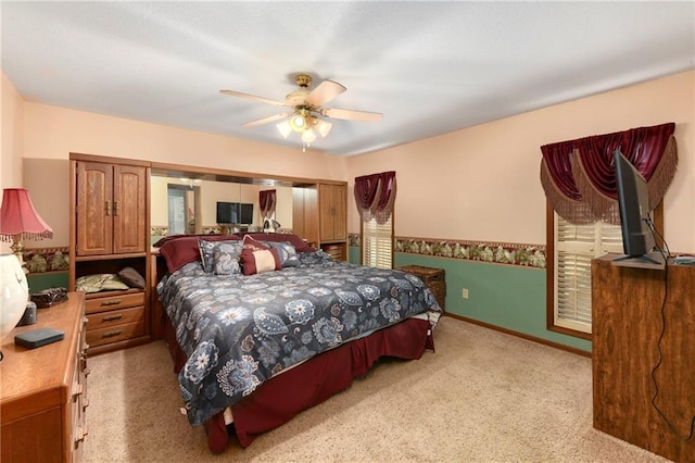 bedroom featuring light carpet, ceiling fan, and baseboards